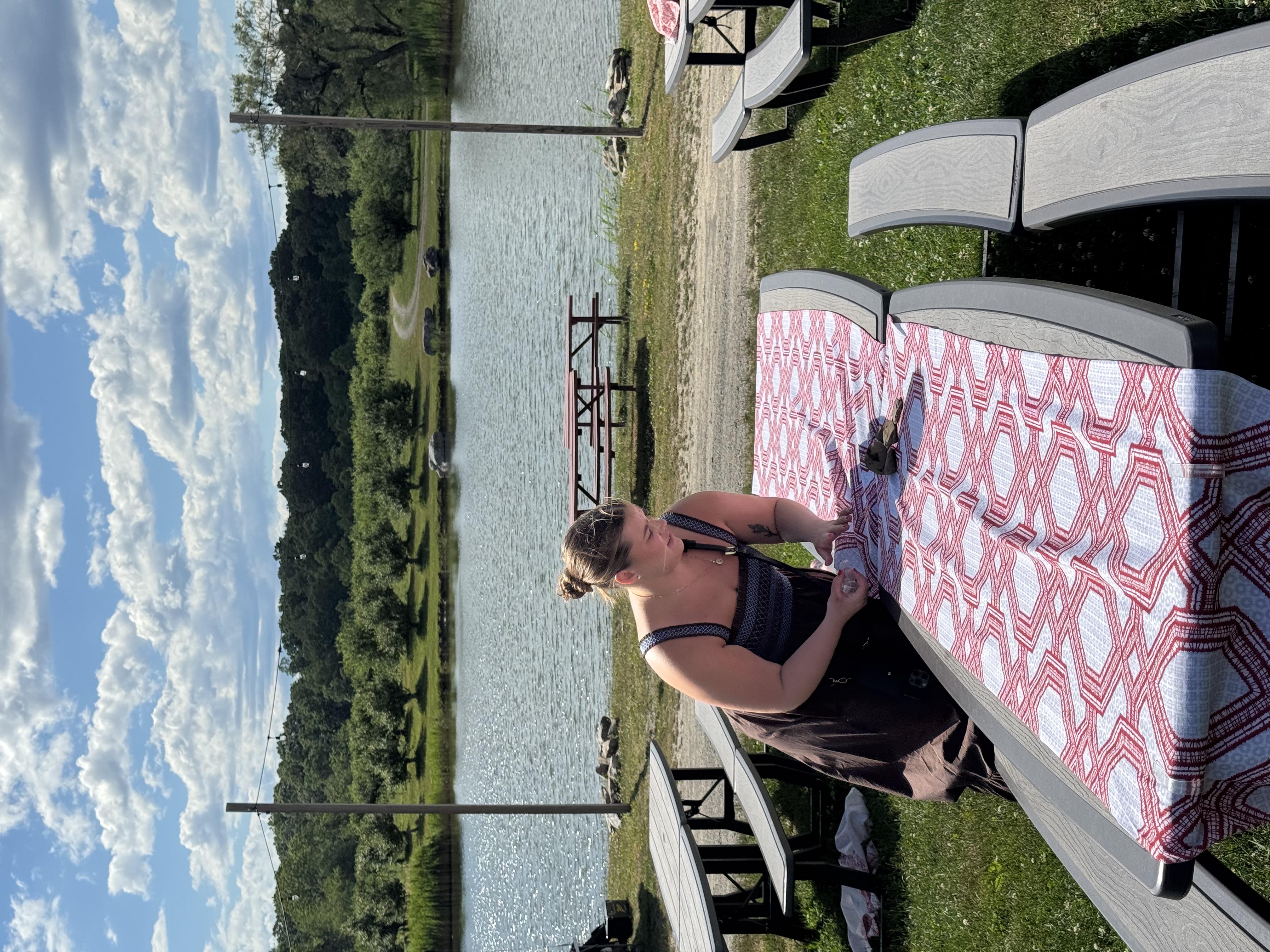 Wedding coordinator preparing reception tables before guests arrive at an outdoor lakeside wedding venue